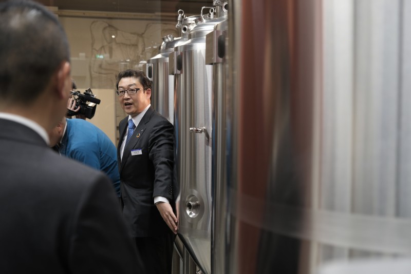 竣工したばかりの醸造所内の説明を行うアルピコホテルズ株式会社ビール事業課の中島係長