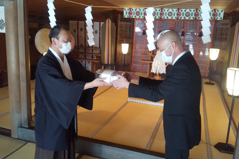 ご祈祷していただいた海苔を宮司から授かる金井料理長（写真右）